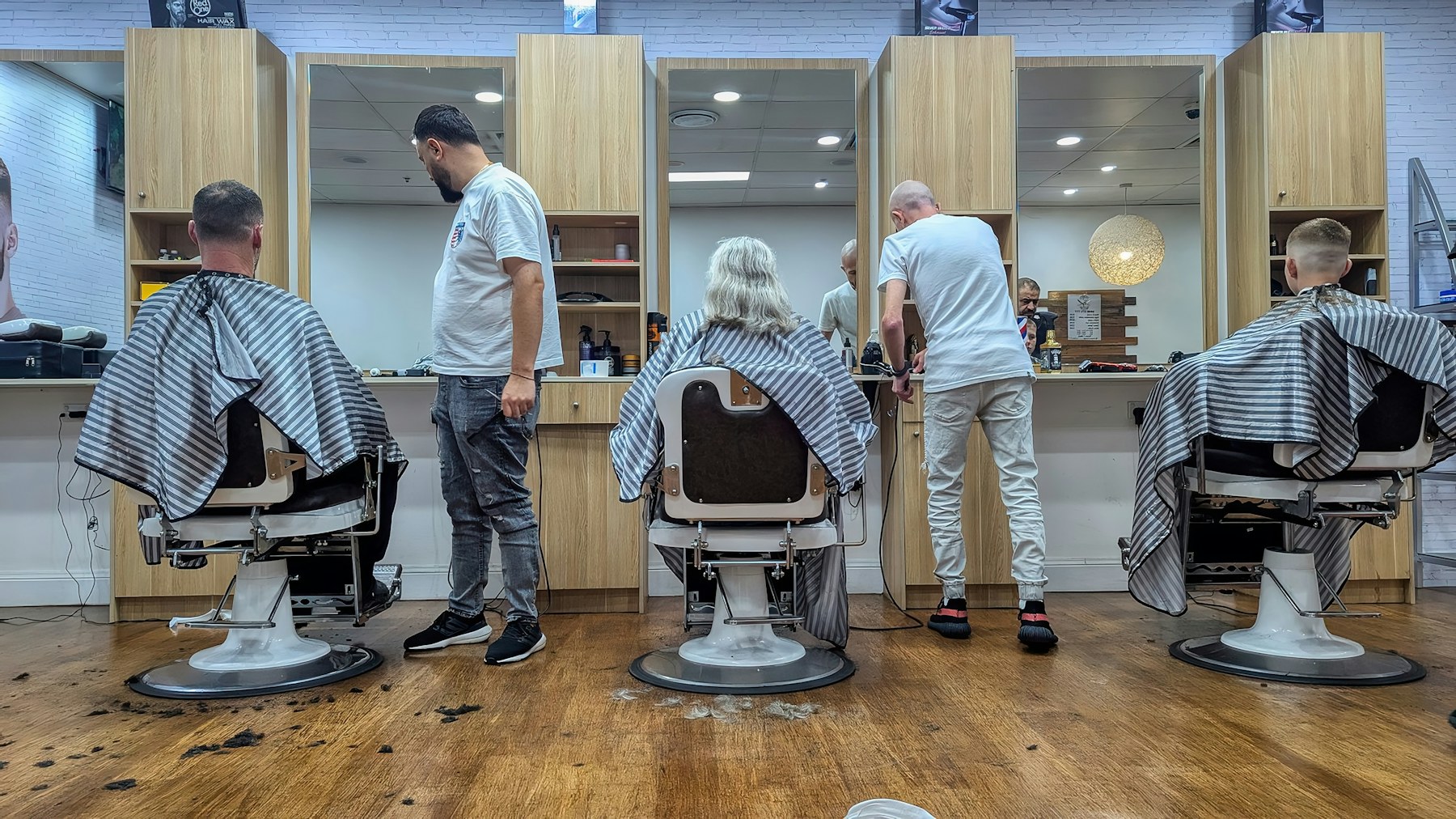 Friseur bei einem präzisen Haarschnitt – Symbolbild